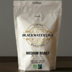 White 12 oz Blackwater Java Roasters coffee bag labeled Medium Roast with circular gold emblem and bold black typography